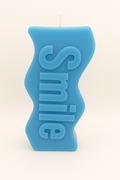 Blue Smile Candle with cheerful smile message in soft blue color, hand-poured soy wax for calming ambiance.