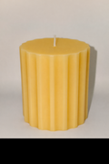 Ribbed cylinder pillar candle in purple, white, and yellow with premium soy wax and elegant textured design